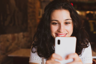 Portrait of smiling woman holding mobile phone