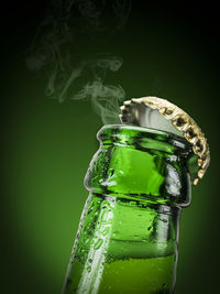 Close-up of green bottle against black background