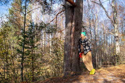 Low angle view of woman standing on tree