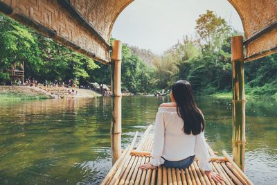 Rear view of woman sitting in garden