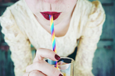 Close-up of woman holding straw in mouth