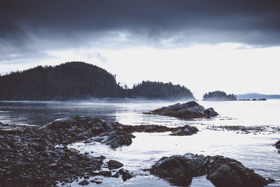 Rocks by sea against sky