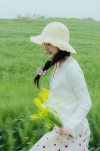 Portrait of young woman standing on field