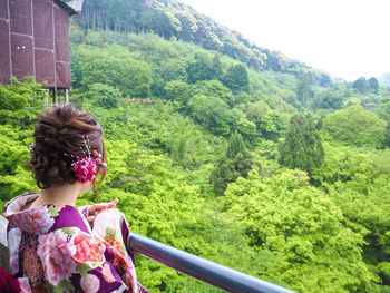 Rear view of woman looking at trees and plants