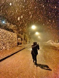 Woman standing on road at night