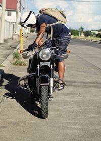 Rear view of man riding bicycle on road