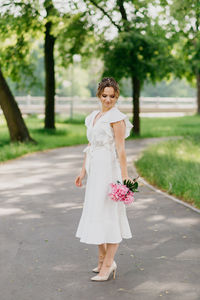 Full length of woman standing against trees