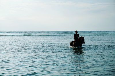 Man in sea against sky