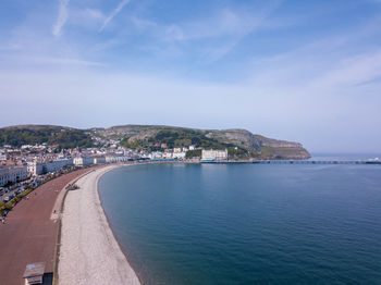 Scenic view of sea by city against sky