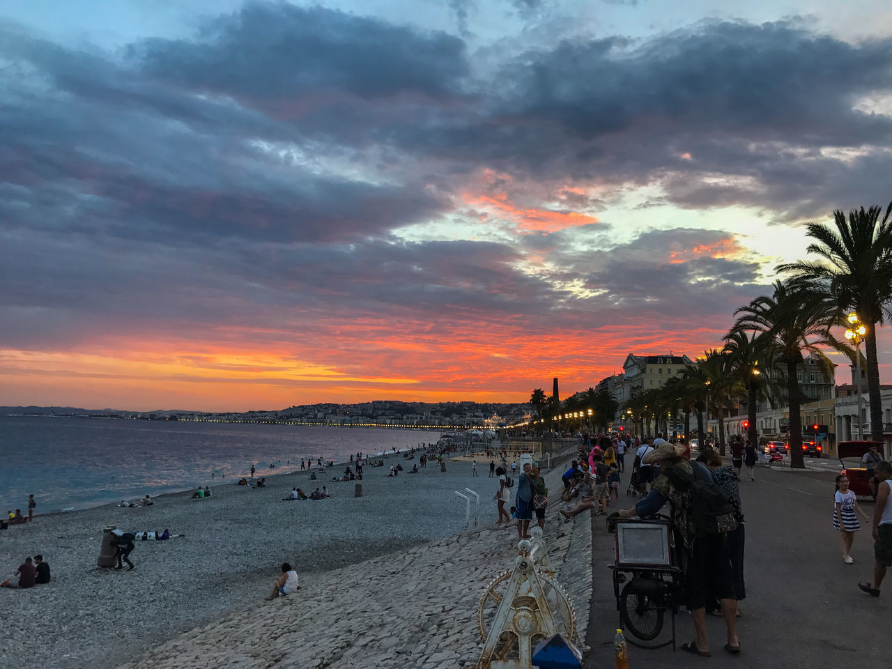 GROUP OF PEOPLE ON BEACH AGAINST SKY DURING SUNSET