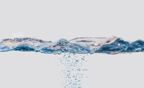 Close-up of water splashing against white background