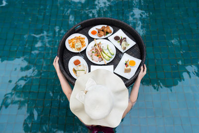 Low section of woman standing on poolside