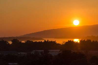 Scenic view of silhouette mountains against orange sky