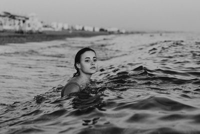 Portrait of young woman swimming in lake