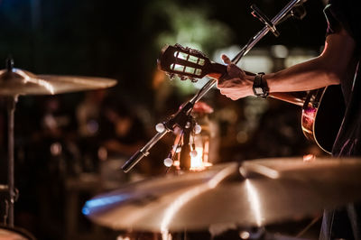 Cropped hand of guitarist playing guitar at music concert