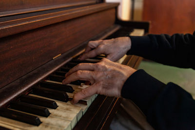 Midsection of man playing piano