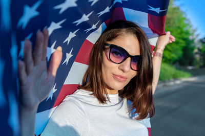 Young woman holding usa flag outdoors at sunset. patriotic holiday. independence day.