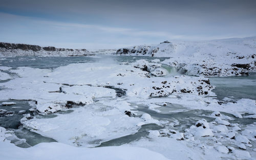 Scenic view of frozen sea against sky during winter