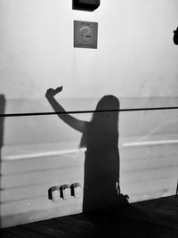 Side view of silhouette woman standing against wall