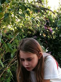 Close-up of beautiful young woman against plants