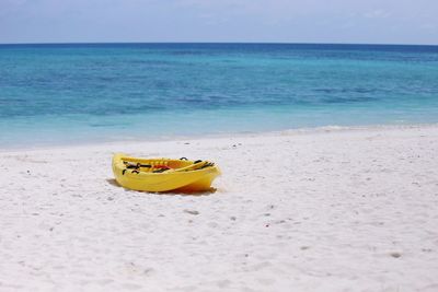 Boat moored at beach against sky