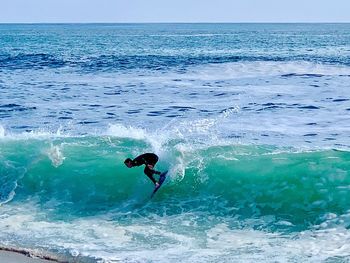 Man surfing in sea against sky