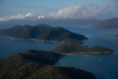 Scenic view of sea by mountains against sky