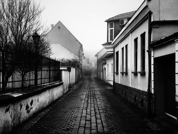 Footpath amidst buildings against sky