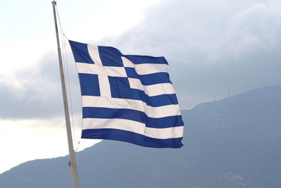 Low angle view of flag on mountain against sky