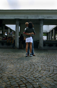Full length rear view of siblings standing outdoors