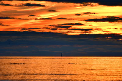Scenic view of sea against dramatic sky during sunset
