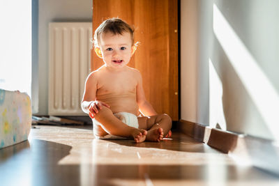 Cute girl sitting on table at home