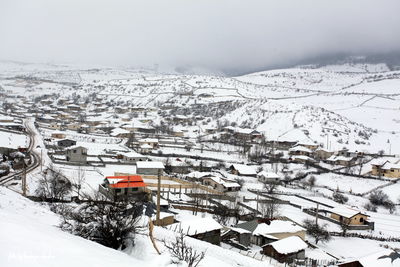 High angle view of snow covered buildings against mountain