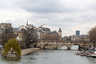 Bridge over river against cloudy sky