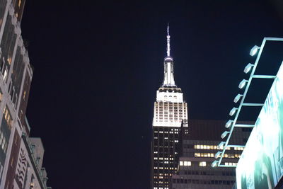 Low angle view of clock tower at night