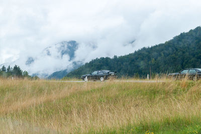 Cars on field against sky