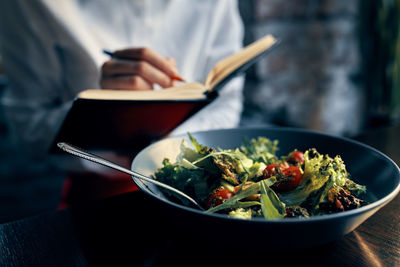 Midsection of person in bowl on table