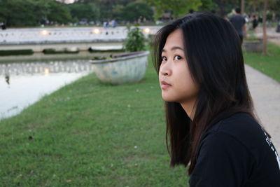 Close-up portrait of young woman in lawn