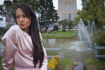 Woman wearing sunglasses while sitting against fountain