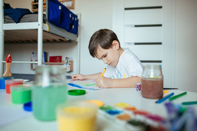 Boy doing painting while sitting at home
