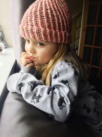 Cute girl wearing knit hat at home