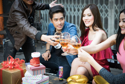 Friends toasting drinks during party