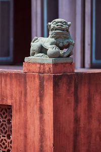 Close-up of old statue against building