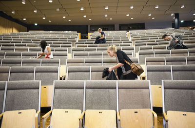 Young men and women leaving auditorium after seminar