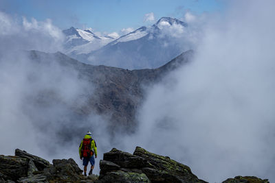 Rear view of person with ice on mountain against sky