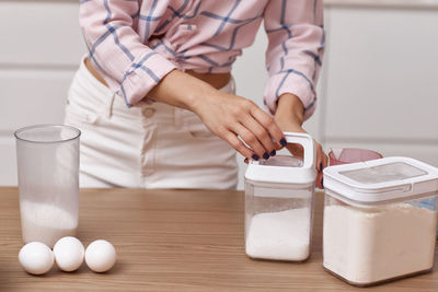 Midsection of woman holding bottle