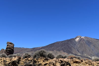 Scenic view of rocky mountains against clear blue sky