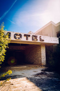 Abandoned motel against sky in sunny day