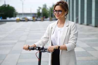 Portrait of young woman standing on street