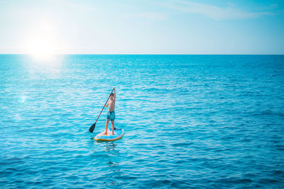 Man in sea against sky